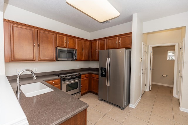 kitchen featuring sink, light tile patterned floors, and appliances with stainless steel finishes