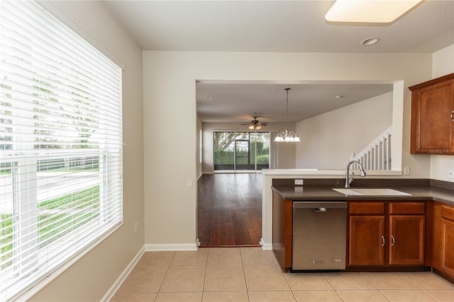 kitchen with light tile patterned flooring, sink, decorative light fixtures, stainless steel dishwasher, and ceiling fan with notable chandelier