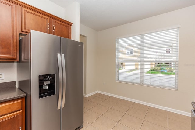 kitchen featuring light tile patterned floors and stainless steel fridge