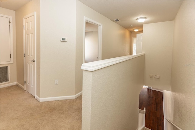 hallway with light colored carpet