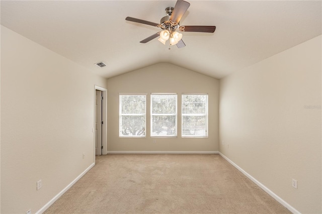 carpeted empty room with vaulted ceiling and ceiling fan