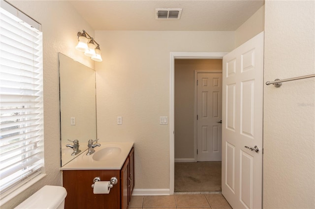 bathroom with tile patterned flooring, vanity, and toilet