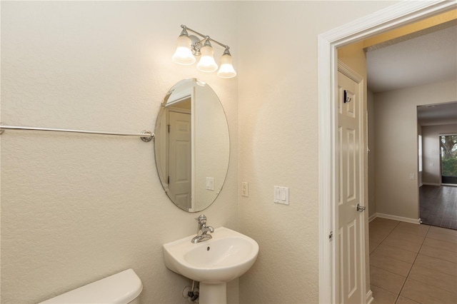 bathroom with tile patterned flooring, sink, and toilet