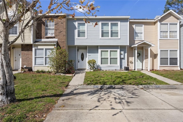 multi unit property with a front lawn and brick siding