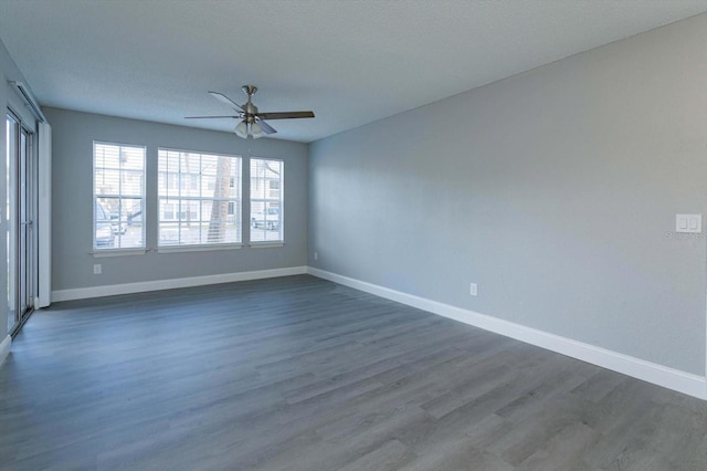 empty room featuring ceiling fan, dark hardwood / wood-style flooring, and a textured ceiling