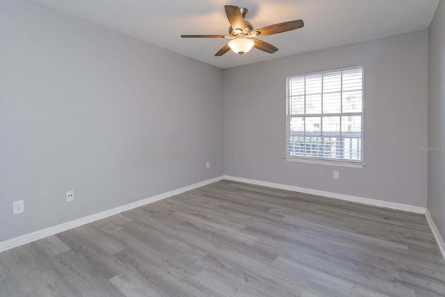 empty room featuring ceiling fan, light hardwood / wood-style flooring, and a textured ceiling