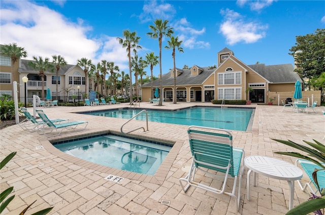 view of swimming pool with a hot tub and a patio area