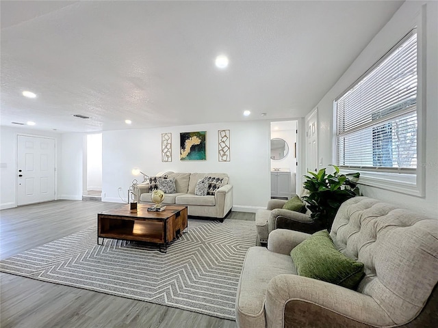 living room with light hardwood / wood-style floors and a textured ceiling