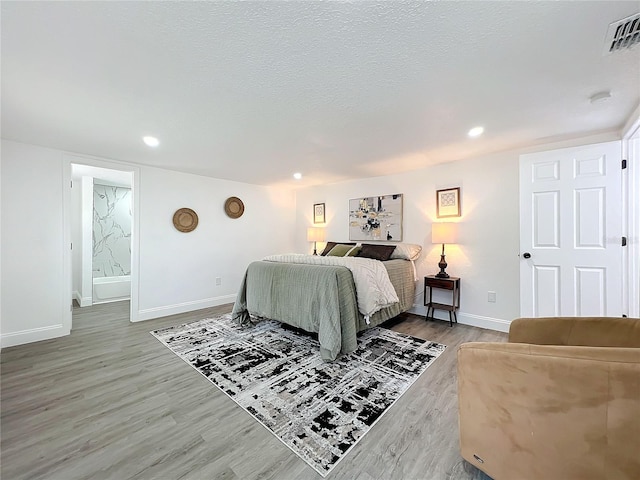 bedroom featuring hardwood / wood-style flooring and a textured ceiling