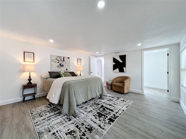 bedroom with hardwood / wood-style floors and a textured ceiling