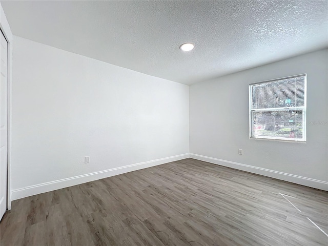 empty room featuring hardwood / wood-style flooring and a textured ceiling