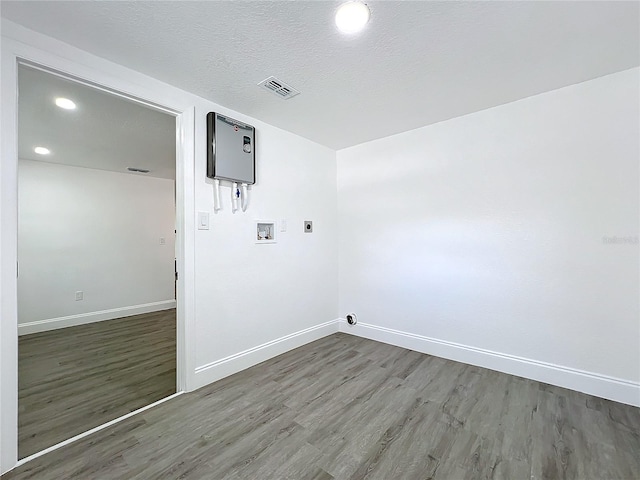 clothes washing area featuring washer hookup, dark wood-type flooring, electric dryer hookup, and a textured ceiling