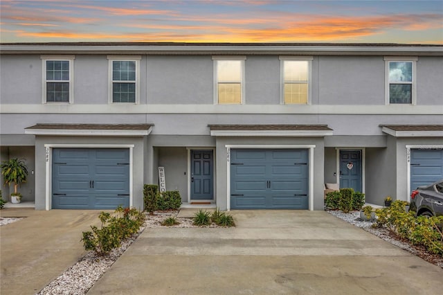 view of front of property featuring a garage, driveway, and stucco siding