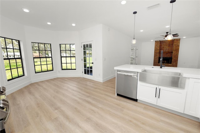 kitchen featuring light countertops, open floor plan, white cabinetry, a sink, and dishwasher