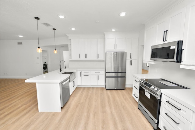 kitchen with appliances with stainless steel finishes, white cabinets, light countertops, and a sink