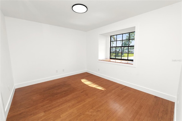 empty room with baseboards and wood finished floors