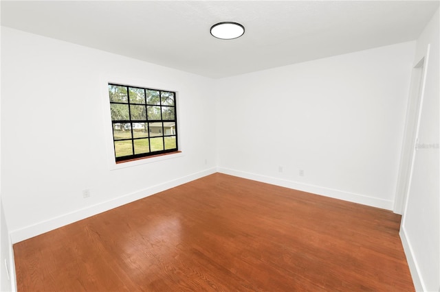 empty room featuring wood finished floors and baseboards