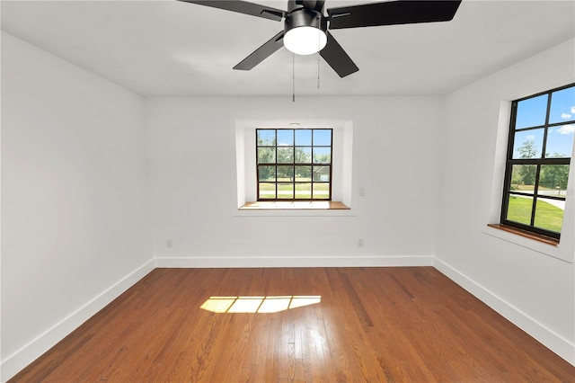 empty room featuring a ceiling fan, baseboards, and wood finished floors