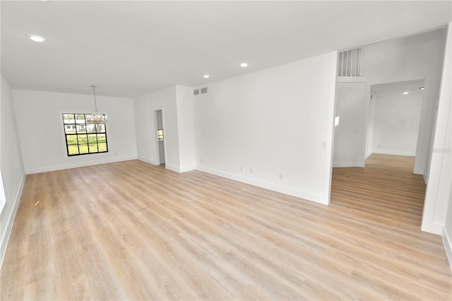 unfurnished room with light wood-style flooring, recessed lighting, visible vents, and an inviting chandelier