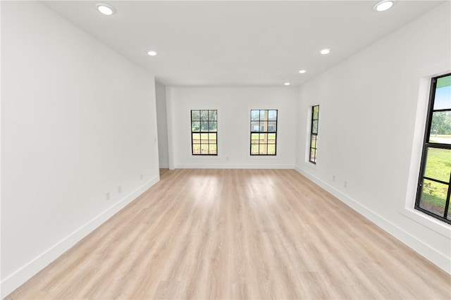 empty room featuring light wood-type flooring, baseboards, and recessed lighting