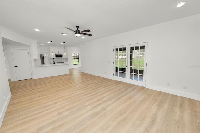 unfurnished living room with light wood-style flooring, baseboards, a ceiling fan, and recessed lighting