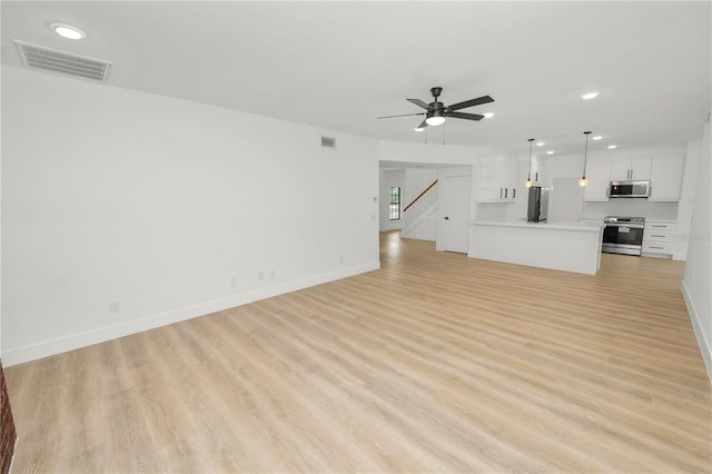 unfurnished living room with baseboards, light wood finished floors, visible vents, and a ceiling fan