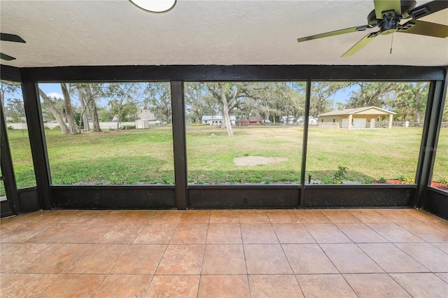 unfurnished sunroom with ceiling fan