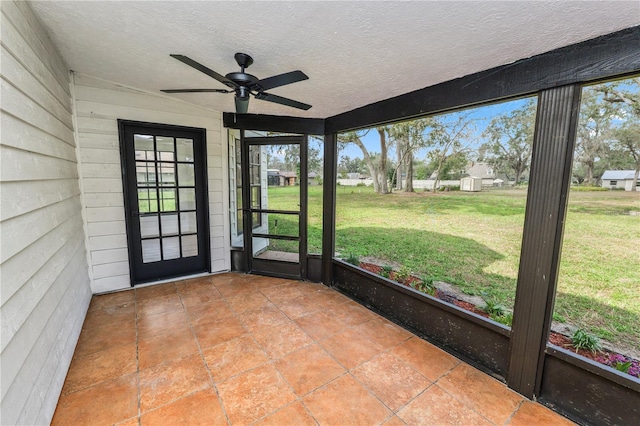 unfurnished sunroom featuring a ceiling fan