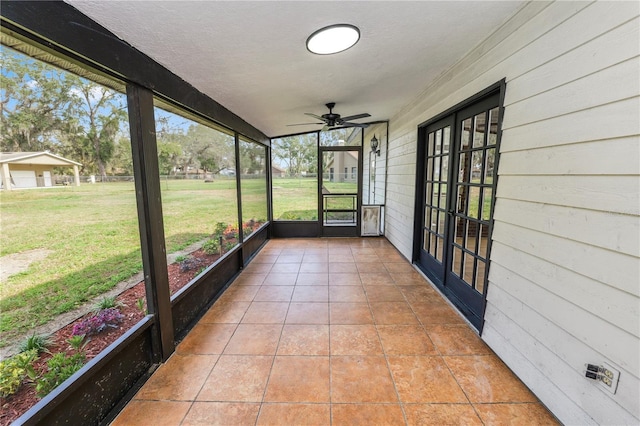 unfurnished sunroom featuring ceiling fan