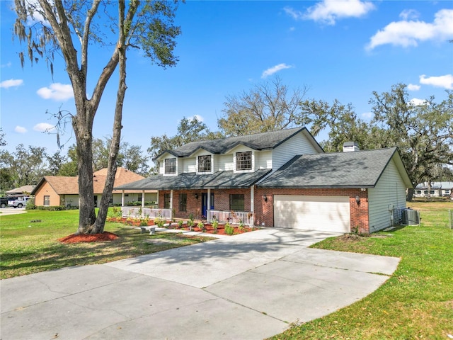 view of front of property with central air condition unit, covered porch, a garage, brick siding, and a front yard