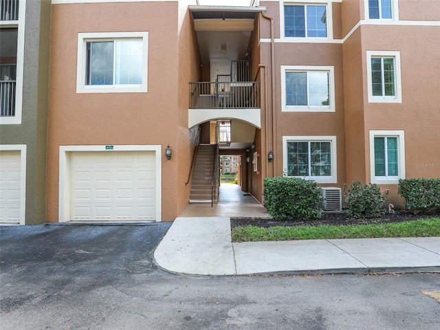 view of property with central AC unit and a garage