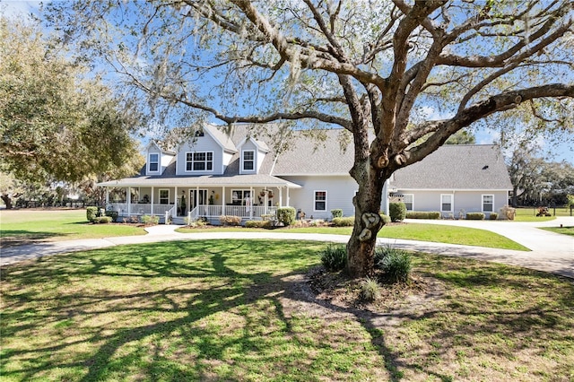 cape cod home featuring a front yard and covered porch