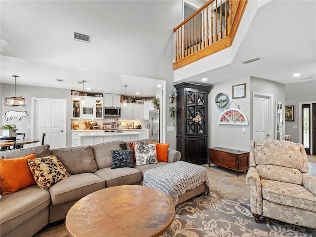 living room featuring a towering ceiling and a chandelier