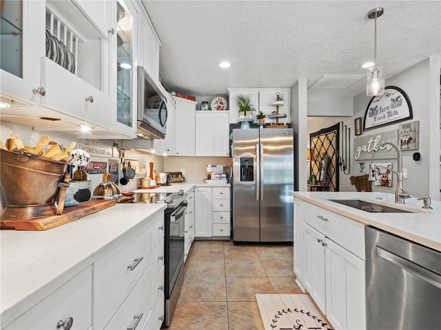 kitchen featuring sink, decorative light fixtures, stainless steel appliances, and white cabinets