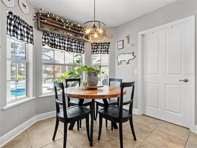 tiled dining space featuring an inviting chandelier