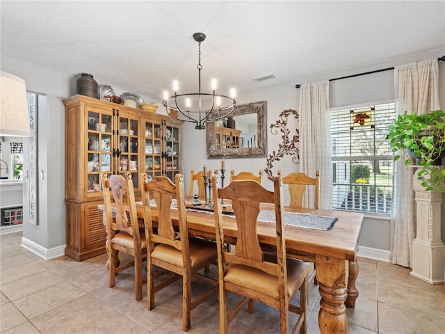 dining space featuring light tile patterned floors and a notable chandelier