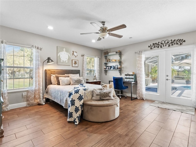 bedroom featuring hardwood / wood-style flooring, ceiling fan, a textured ceiling, access to outside, and french doors