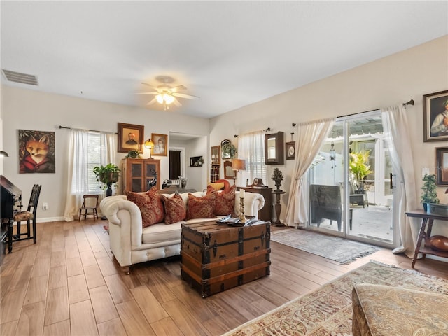 living room featuring ceiling fan and light hardwood / wood-style floors