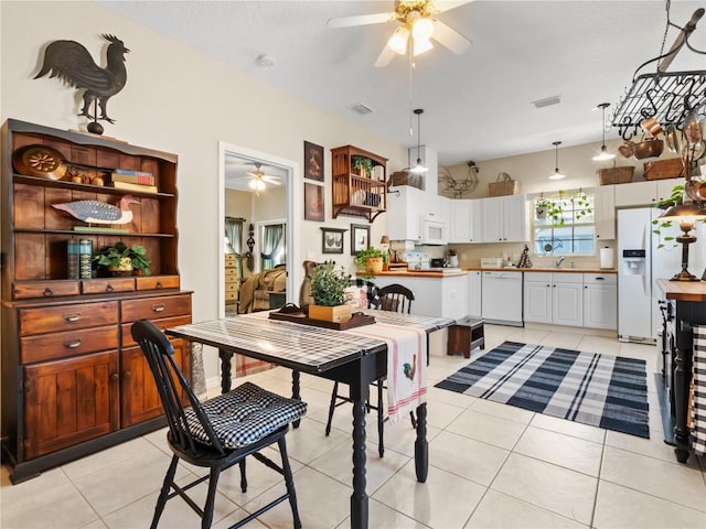 dining room featuring light tile patterned floors, a textured ceiling, sink, and ceiling fan