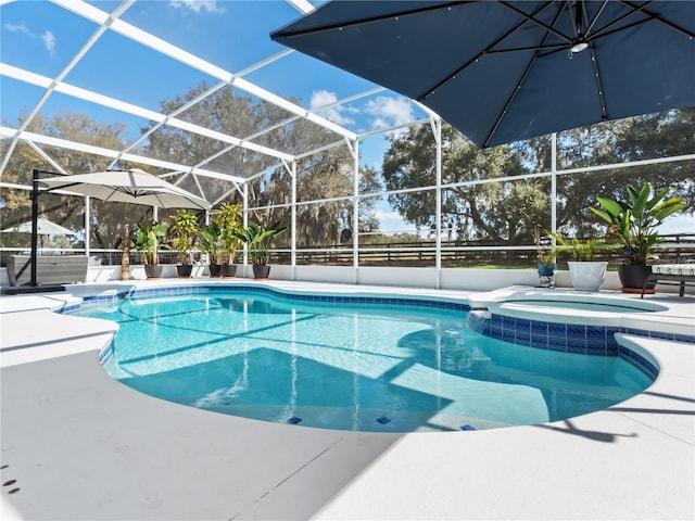 view of pool featuring an in ground hot tub, a patio, and glass enclosure