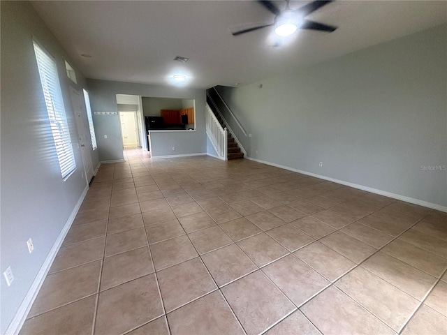 unfurnished living room featuring light tile patterned floors and ceiling fan