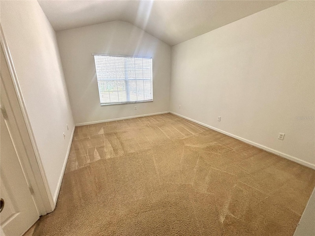 spare room with lofted ceiling and carpet flooring