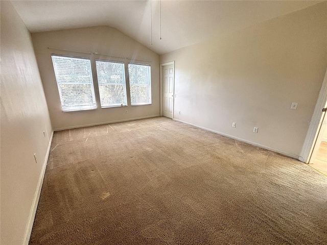 carpeted empty room featuring vaulted ceiling