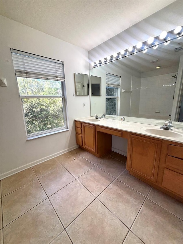 bathroom featuring vanity, tile patterned floors, a textured ceiling, and a tile shower