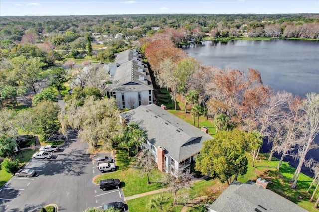 birds eye view of property featuring a water view and a wooded view