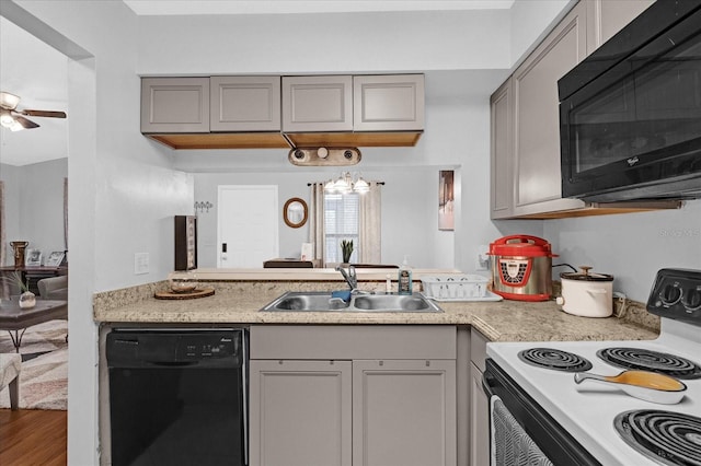 kitchen featuring gray cabinets, light countertops, a sink, and black appliances