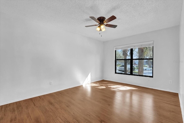 unfurnished room featuring ceiling fan, a textured ceiling, baseboards, and wood finished floors