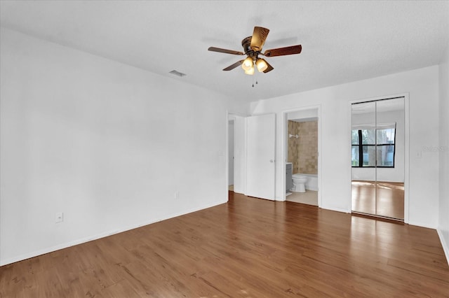 interior space with visible vents, ceiling fan, baseboards, and wood finished floors