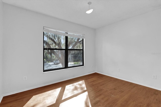 spare room with wood finished floors and baseboards