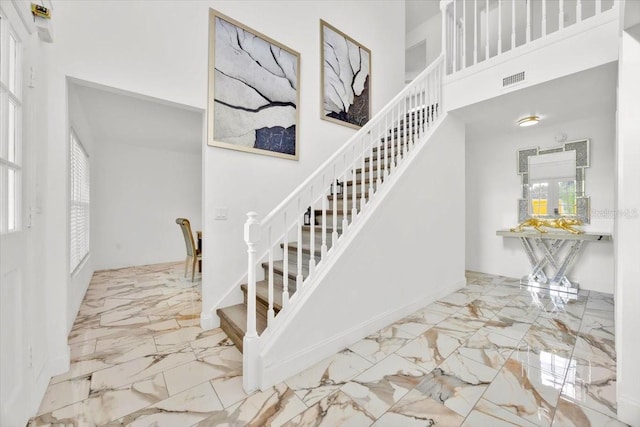 5108 Avignon Ct, Orlando, FL 32839 - staircase with marble tiled flooring, a towering ceiling, and baseboards